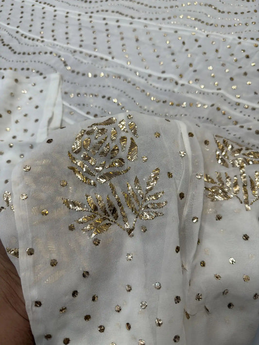 Close-up of handcrafted gold-toned Mukaish and floral embroidered border on a Lucknowi Chikankari dress