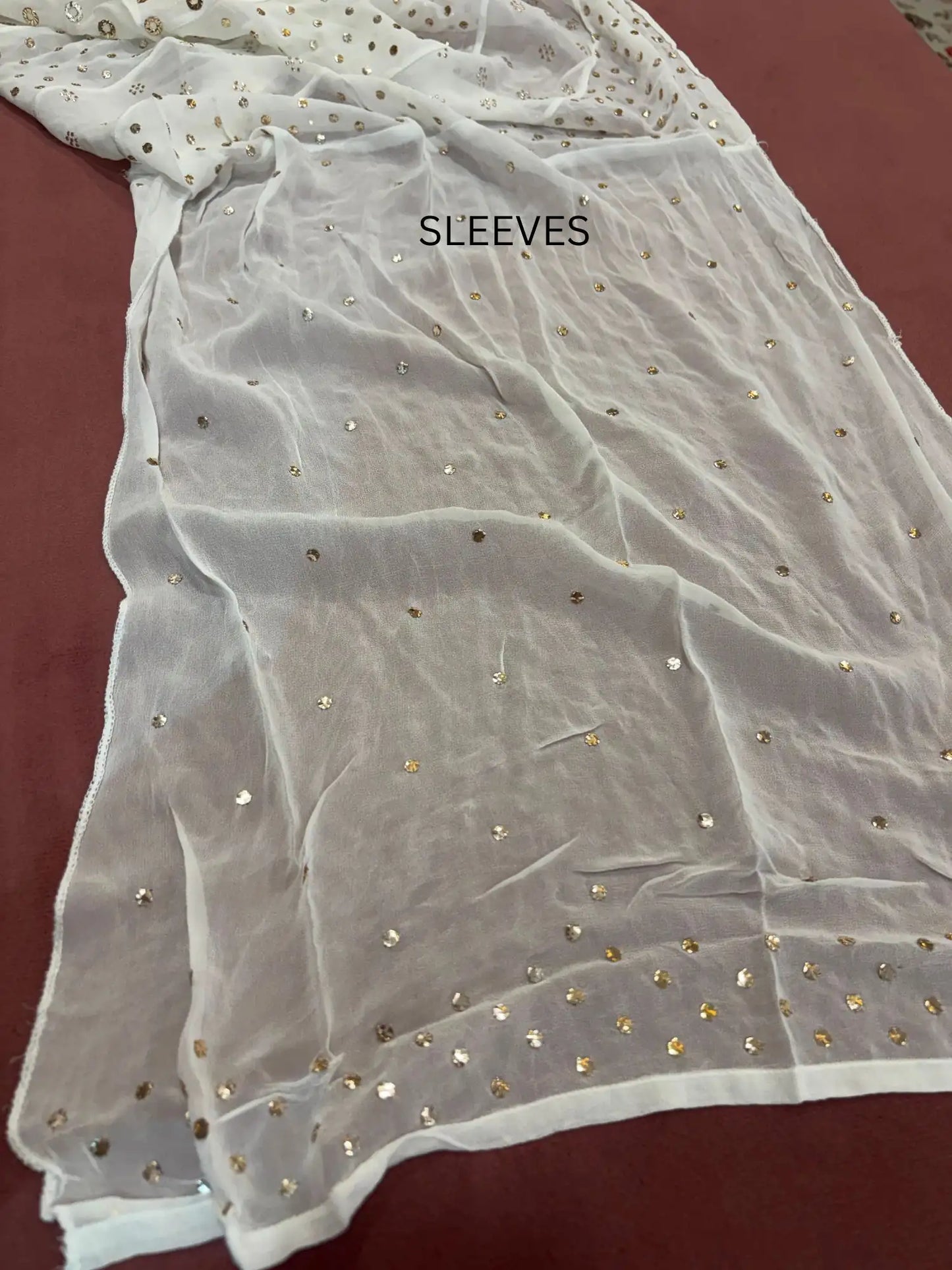 Full sleeves featuring handcrafted gold-toned Mukaish work on a Lucknowi Chikankari dress