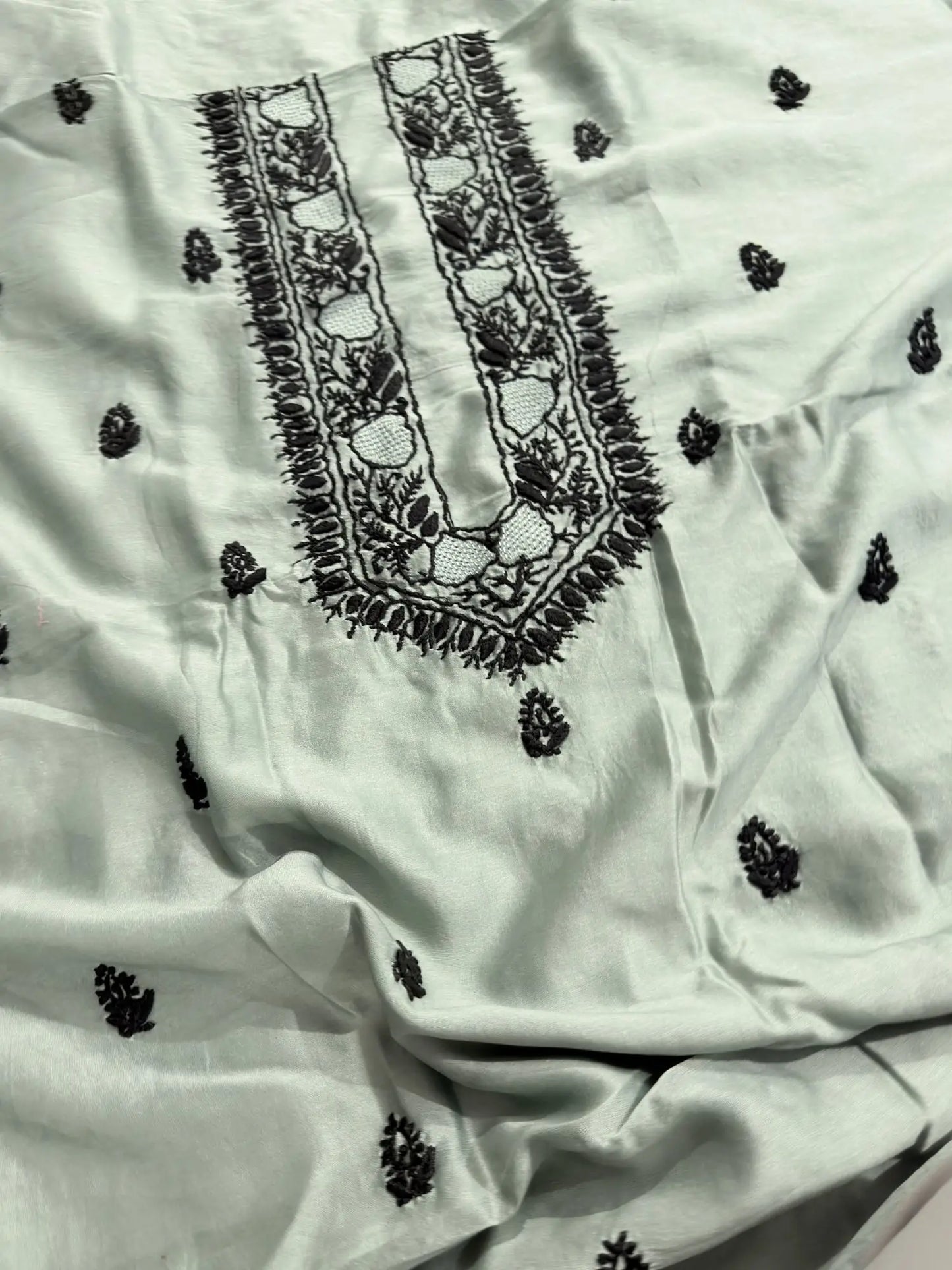 Intricate black Lucknowi Chikankari embroidery on the neckline of Celadon Green Chanderi Silk unstitched kurta fabric.