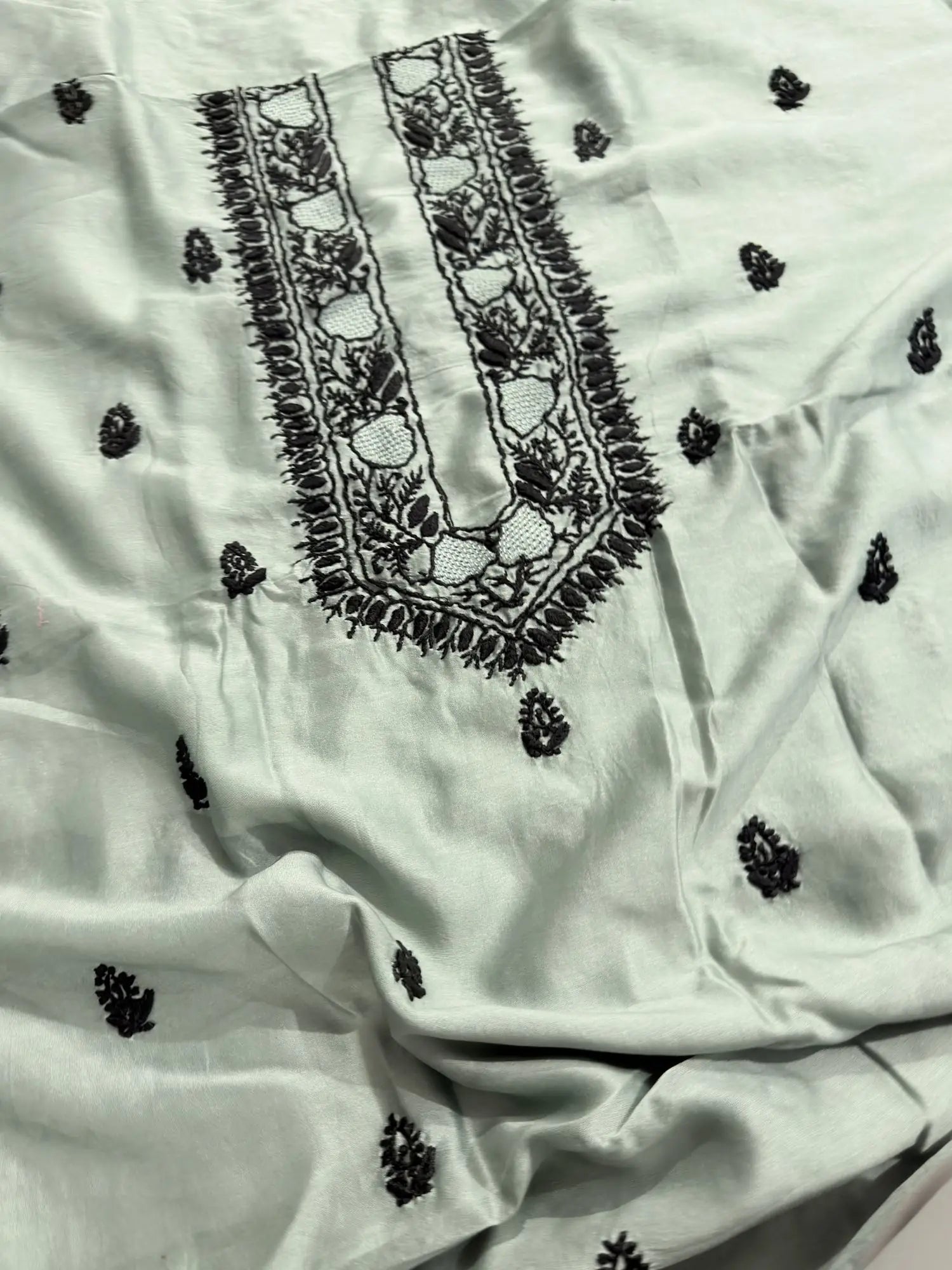 Intricate black Lucknowi Chikankari embroidery on the neckline of Celadon Green Chanderi Silk unstitched kurta fabric.