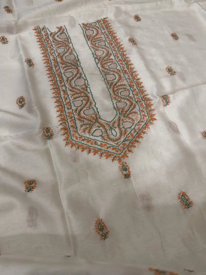 Close-up of peach and sage green Lucknowi Chikankari embroidery on the neckline of ivory dyeable Chanderi Silk fabric.