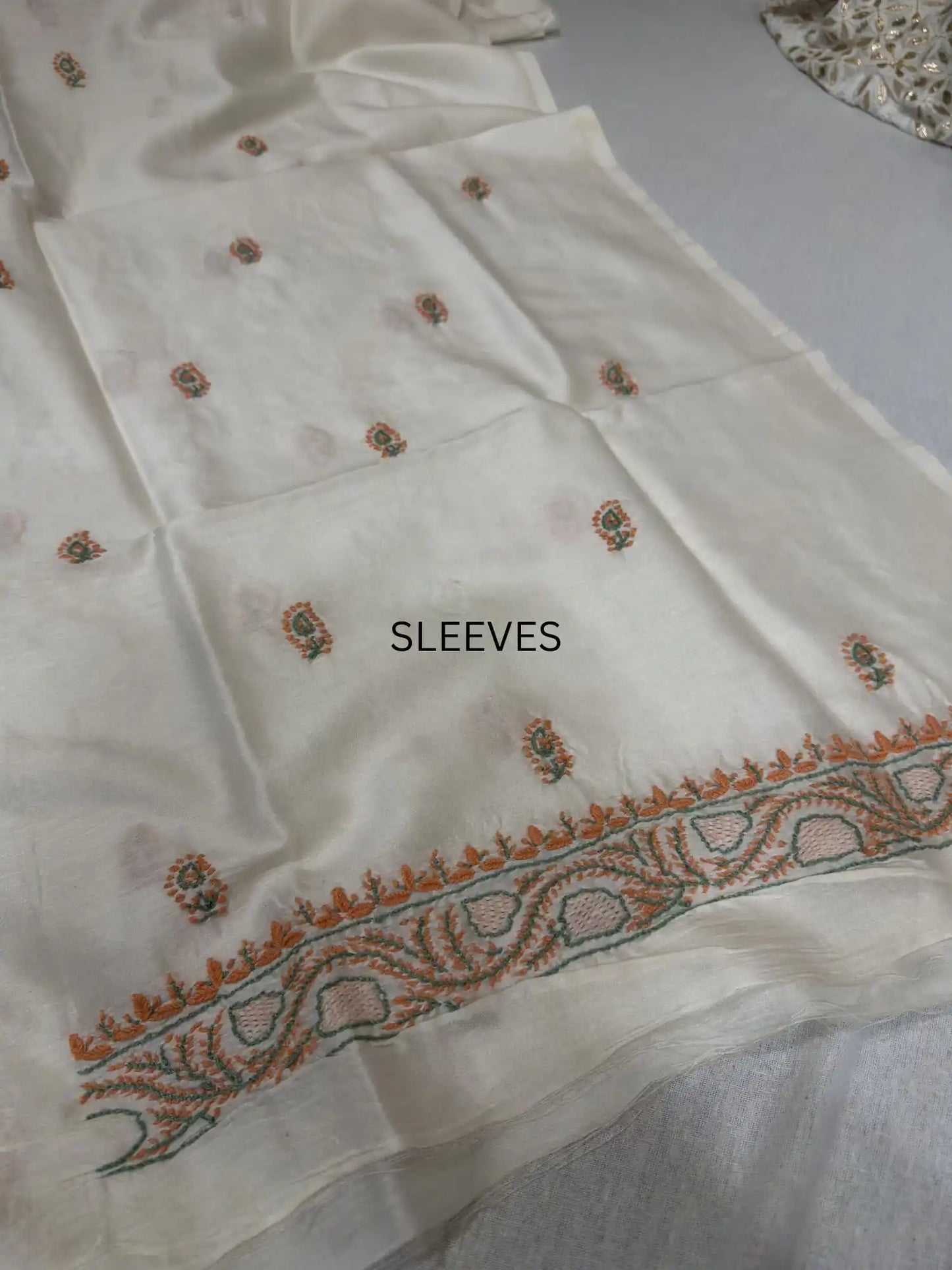 Elegant peach and sage green Lucknowi Chikankari sleeve embroidery on ivory dyeable Chanderi Silk kurta fabric.