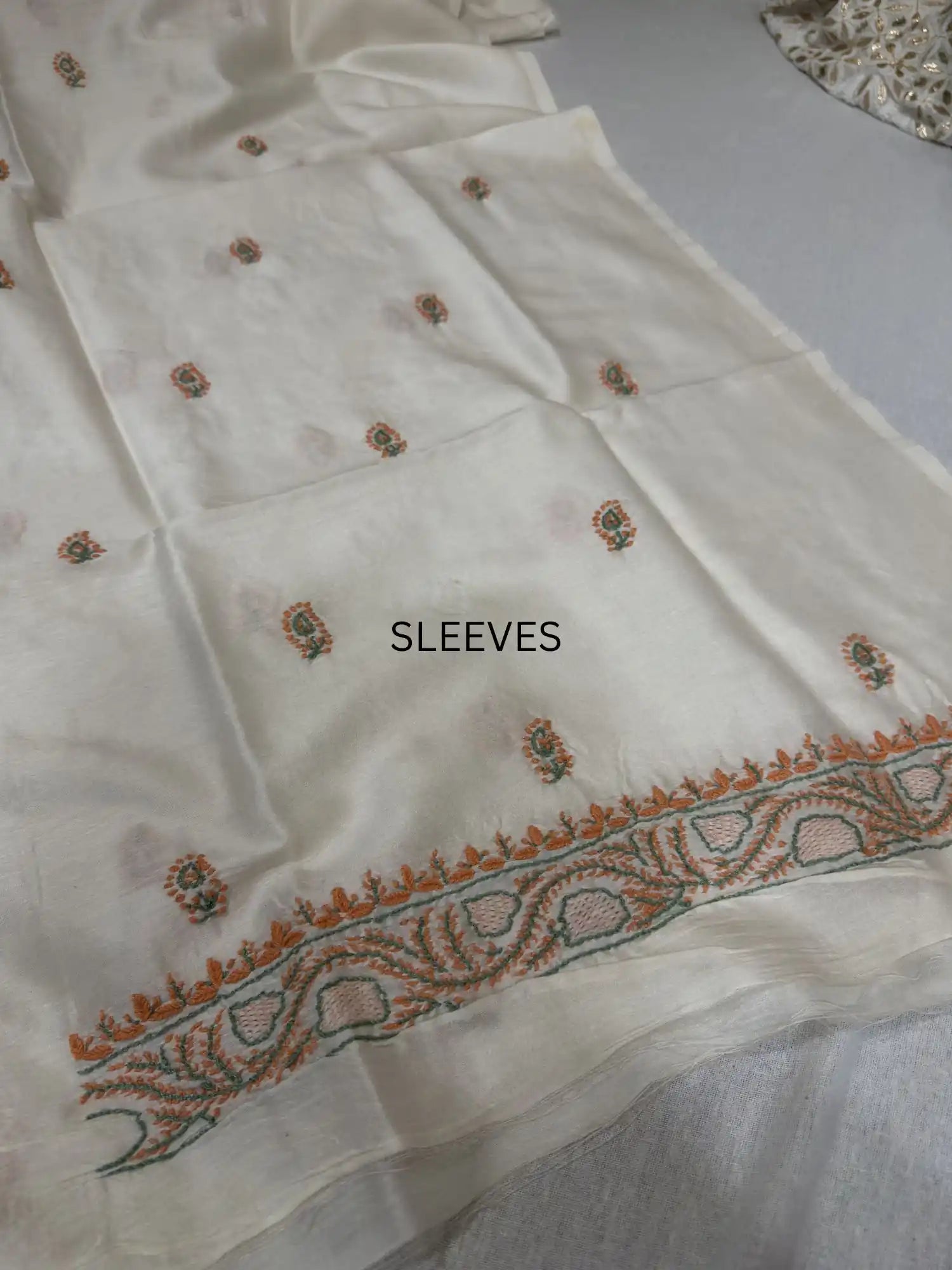 Elegant peach and sage green Lucknowi Chikankari sleeve embroidery on ivory dyeable Chanderi Silk kurta fabric.