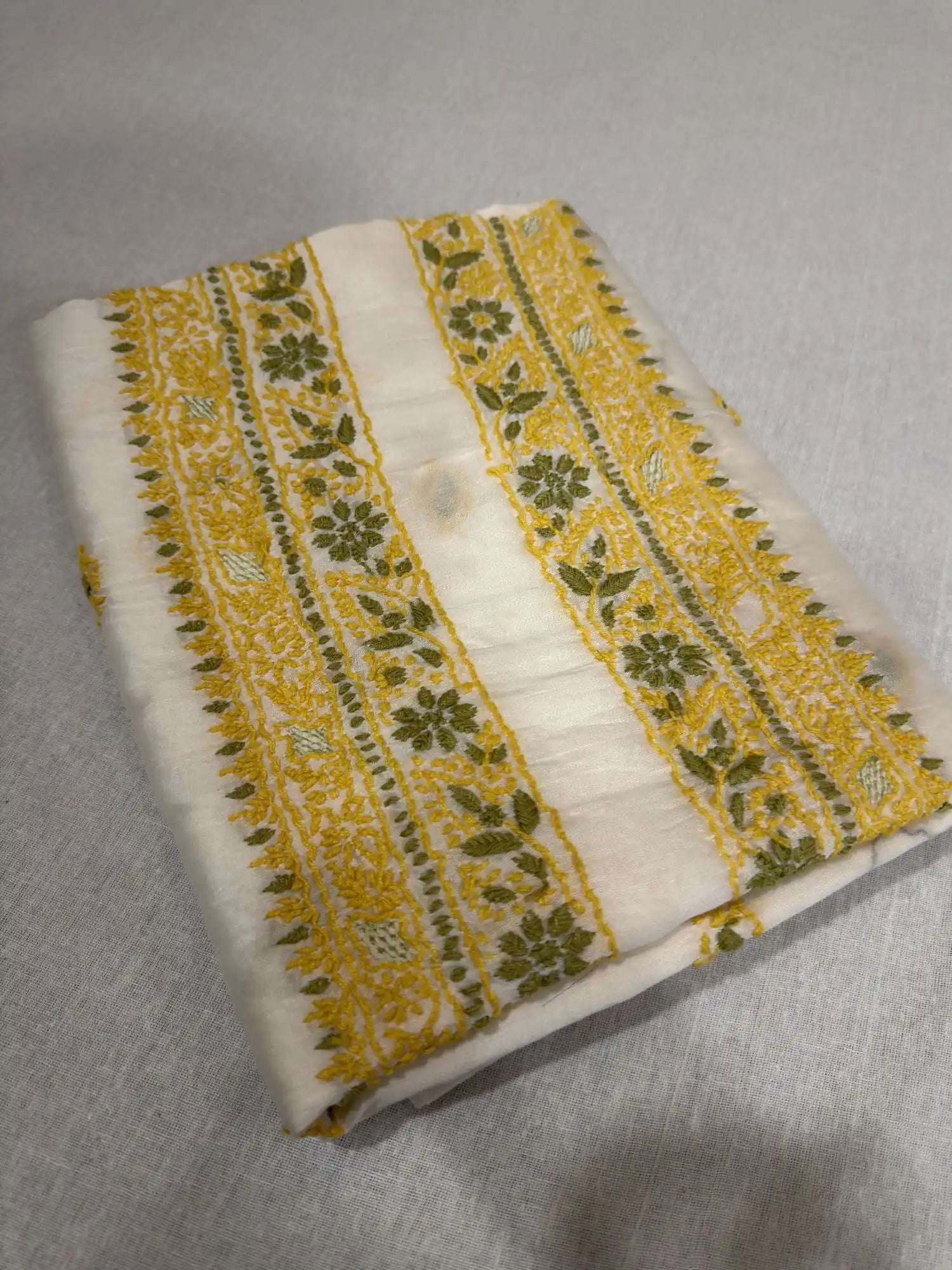 Close-up of premium ivory dyeable Chanderi Silk fabric showcasing authentic Lucknowi Chikankari embroidery and fine woven texture.