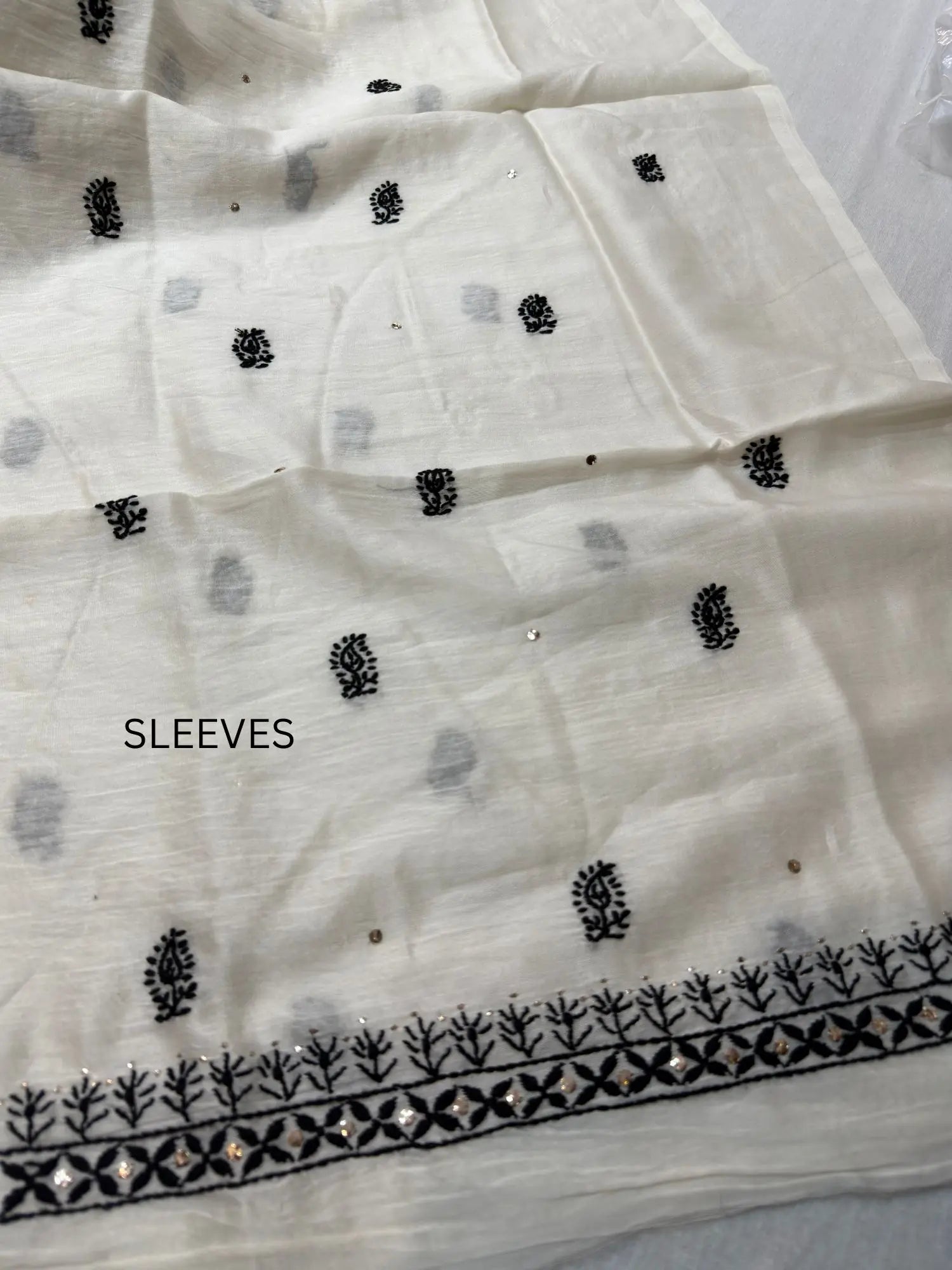 Fine Chikankari embroidery and hand Mukaish detailing on the sleeve of Ivory White Chanderi Silk kurta fabric.