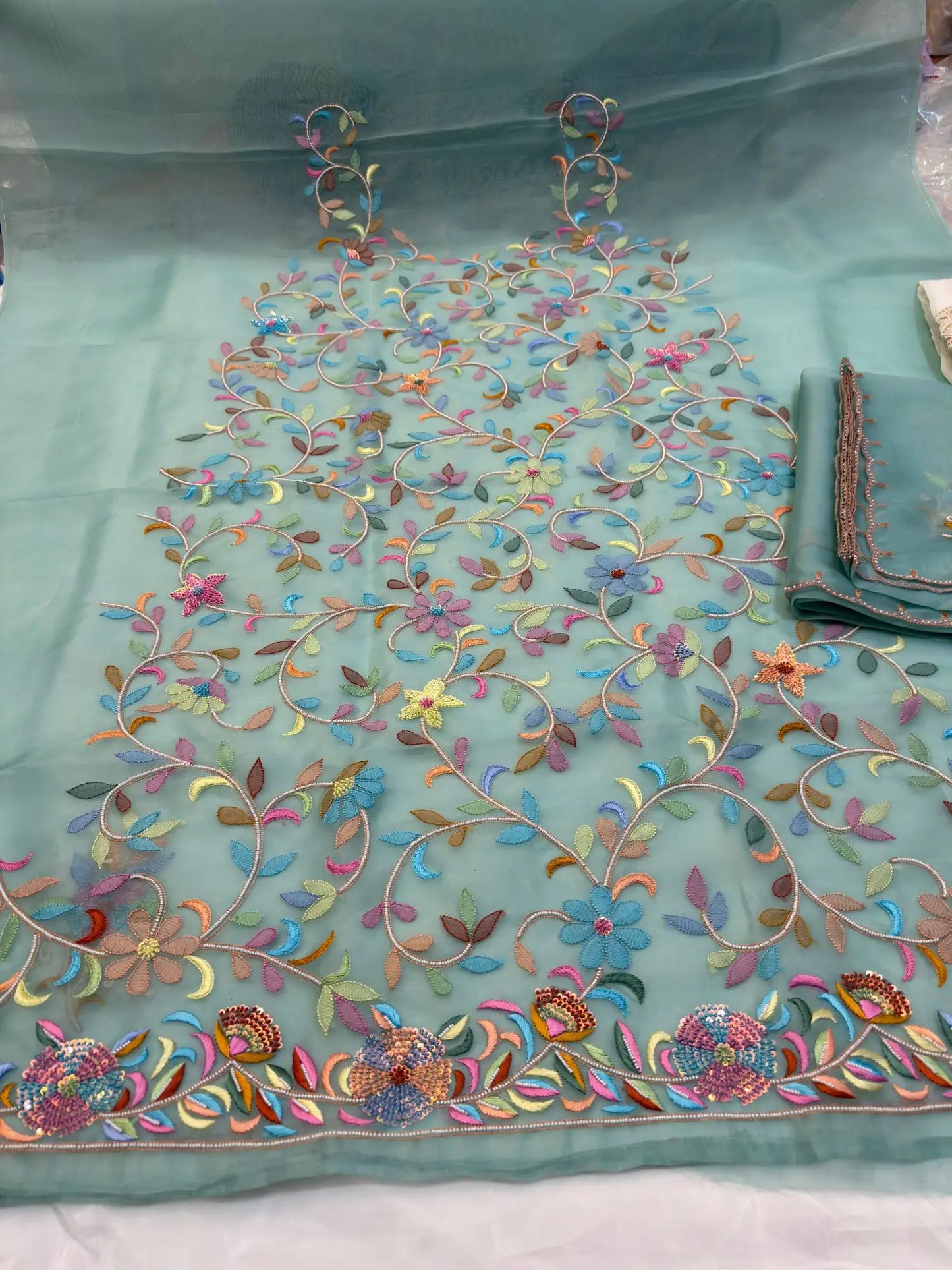 Neck detail of mint green Pure Organza Silk suit with floral embroidery and pearl detailing