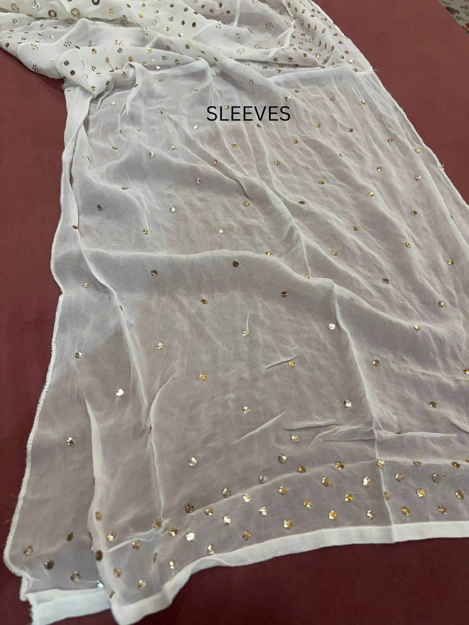 Full sleeves featuring handcrafted gold-toned Mukaish work on a Lucknowi Chikankari dress