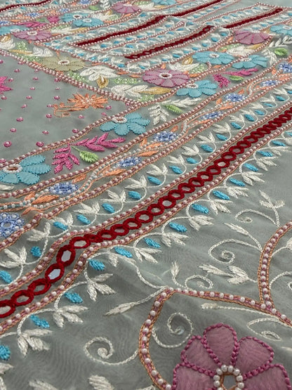 Close-up of pastel sea green Pure Organza suit with floral embroidery and pearl detailing