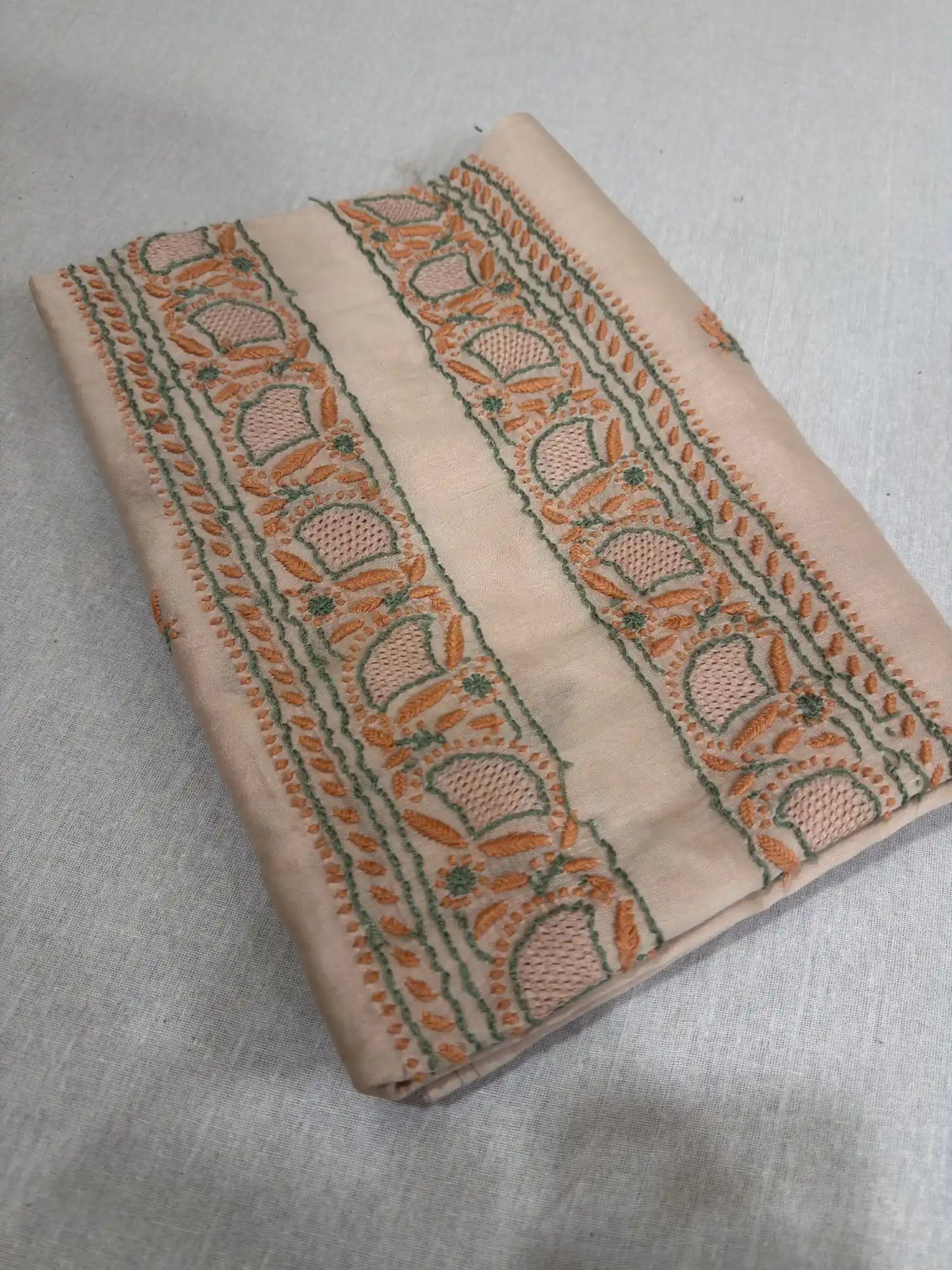 Close-up of peach and green Lucknowi Chikankari embroidery on the neckline of Peach Blush Chanderi Silk kurta fabric.