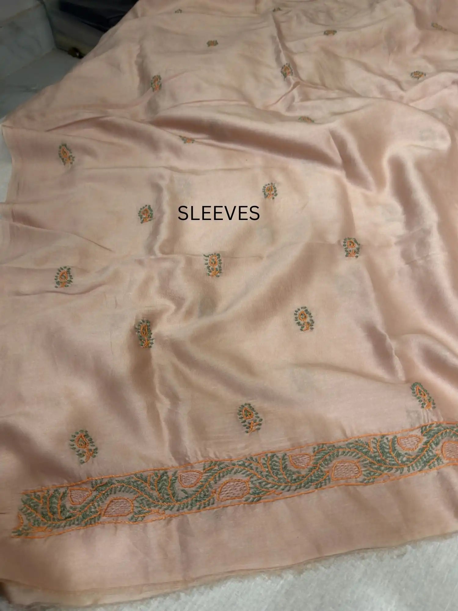 Elegant peach and green Chikankari sleeve embroidery on Peach Chanderi Silk kurta fabric.
