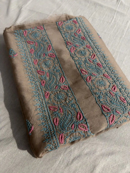 Folded Taupe Brown Chanderi Silk Lucknowi Chikankari kurta fabric showcasing elegant turquoise and pink embroidery.